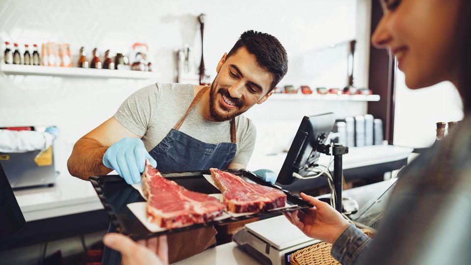 Consumer Choosing Steak at Retail Counter
